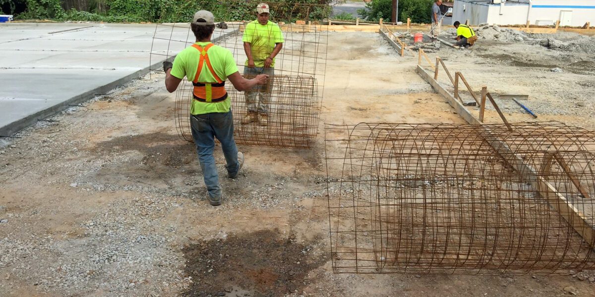 Mad Jack's Asphalt & Concrete, LLC rolling out wire mesh steel in preparation for commercial concrete