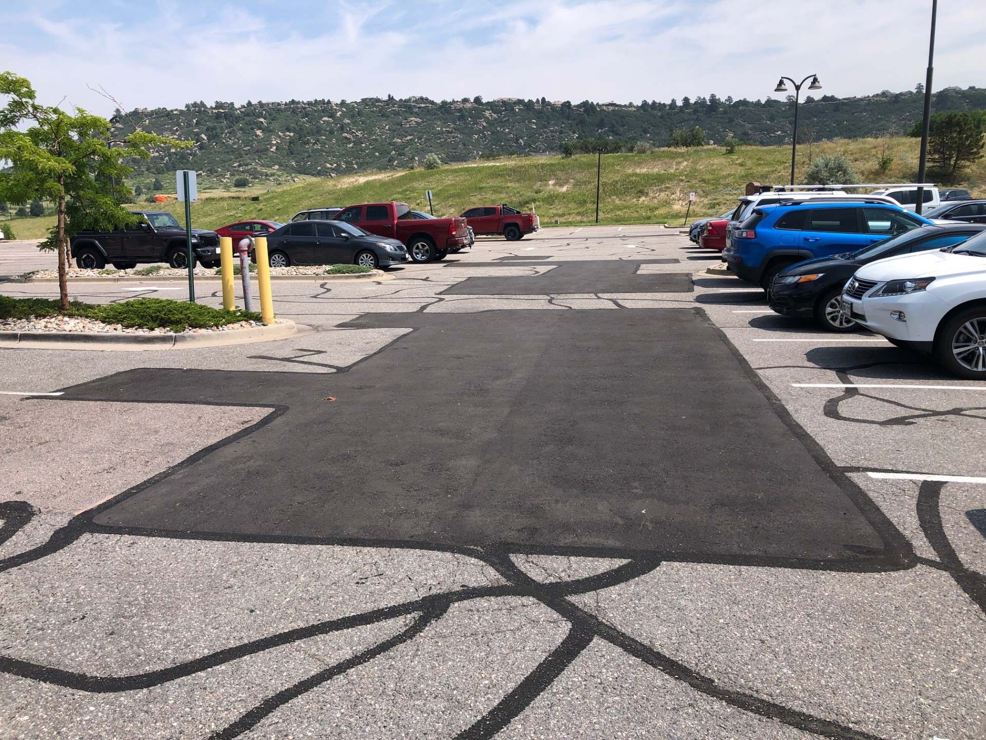 Fresh crackseal and infrared asphalt patching done on a previously damaged parking lot surface by Mad Jack's Asphalt & Concrete